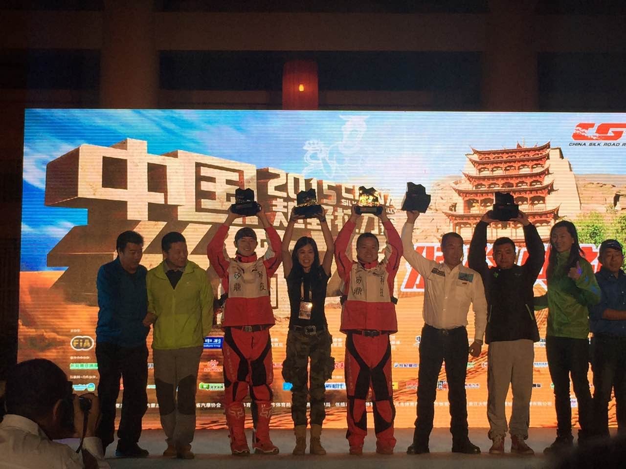 2015年中国越野拉力赛颁奖现场,李铁军团队成员举起奖杯。